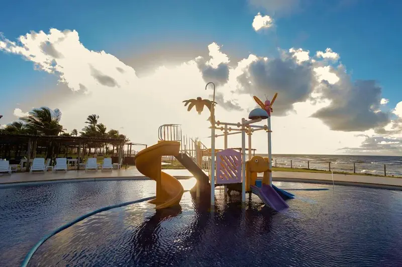 Playground aquático com escorregadores na piscina infantil, de frente para o mar