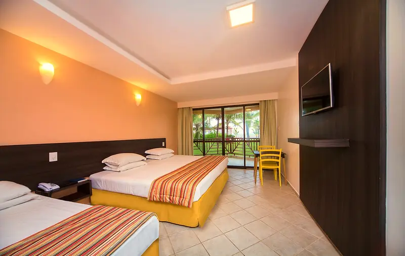 Apartamento Superior Vista Mar com cama de casal, TV e porta de vidro para a varanda