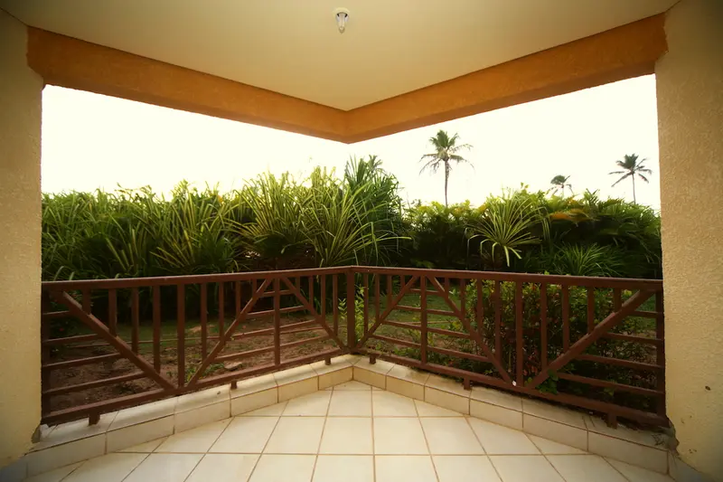 Varanda do apartamento Superior com guarda-corpo de madeira e vista para o jardim