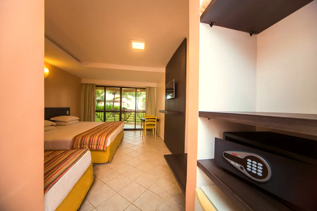 Apartamento Superior Vista Mar com cofre eletrônico, prateleiras e a cama ao fundo